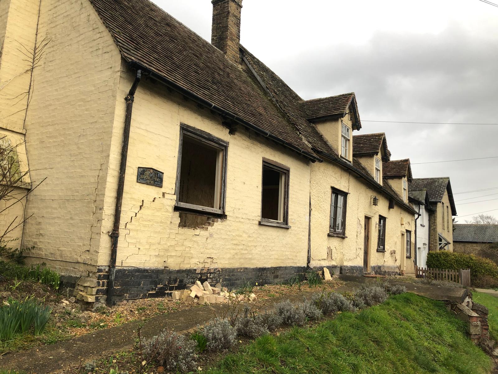 Period renovation — original exterior before work, cracked brickwork and boarded windows